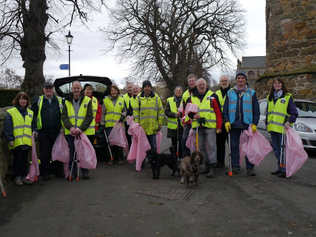 Volunteers of Friends of the River Tyne standing with hi vis jackets and pink bin bags